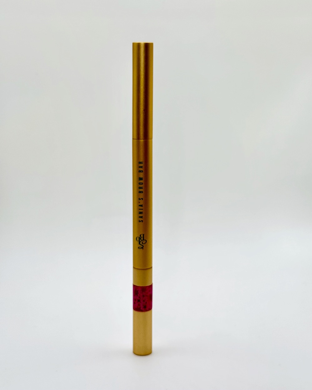 Gold Sania’s Brow Bar brow pencil with a band of sparkly pink tape